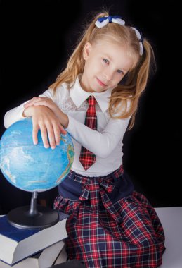 Siyah arka plan, eğitim ve okul kavramı üzerinde oturan küre ile kız öğrenci