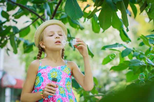 Carino Ragazza Cappello Soffiando Bolle Sapone Tra Gli Alberi — Foto Stock