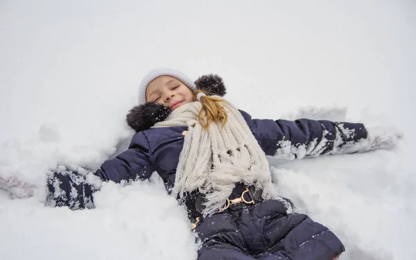 Glückliches Kindermädchen Liegt Winterpark Auf Schnee — Stockfoto