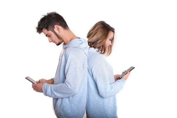Unhappy couple backwards with their mobile phones typing isolate — Stock Photo, Image