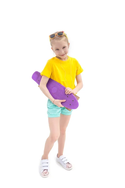 Flicka som står med violete skateboard isolerade — Stockfoto
