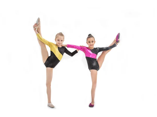 Twee gymnastische meisjes met been omhoog geïsoleerd op wit — Stockfoto