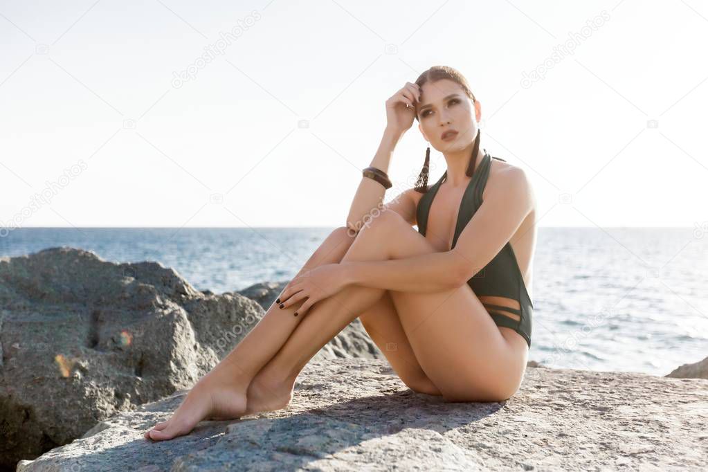 Beautiful athletic girl in a swimsuit on the background of the sea