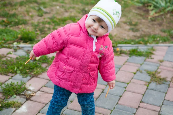 Kis aranyos, vidám lány 1 éves a séta mosolyog, úgy néz ki Stock Fotó