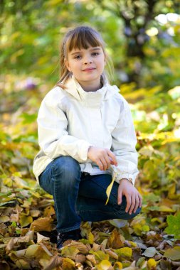 güzel kız beyaz spor ceket ve kot karşı çömelmiş TH