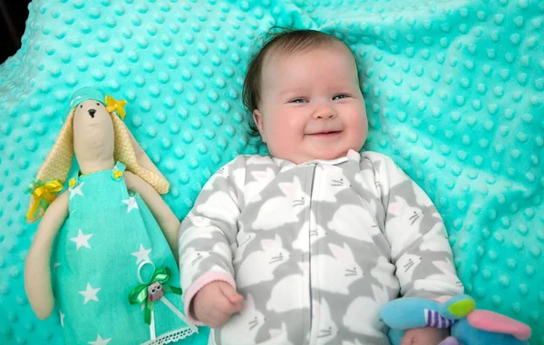 6 місяців маленька дівчинка лежить на м'ятному яскравому килимку з ручкою — стокове фото