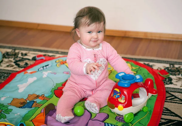 stock image a little girl in a pinksitting   is chidit on a color developmen