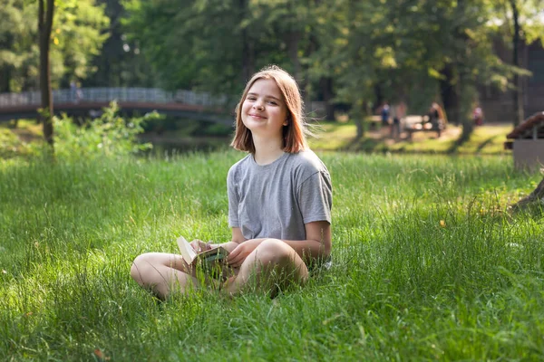 Χαριτωμένο Έφηβος Κορίτσι Κάθεται Ένα Πάρκο Ένα Φόντο Πρασίνου Rea — Φωτογραφία Αρχείου