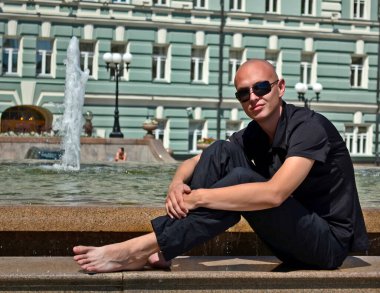 Çeşitli yerlerin arka planında yakışıklı bir genç var..