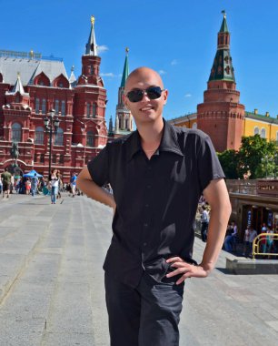 Çeşitli yerlerin arka planında yakışıklı bir genç var..