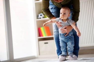 Küçük erkek çocuk annesi ile onun ayak üzerinde yürümek öğrenme