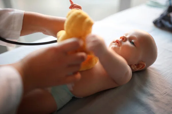 Bom Bebê Olhando Seu Brinquedo Enquanto Pediatra Verificando — Fotografia de Stock