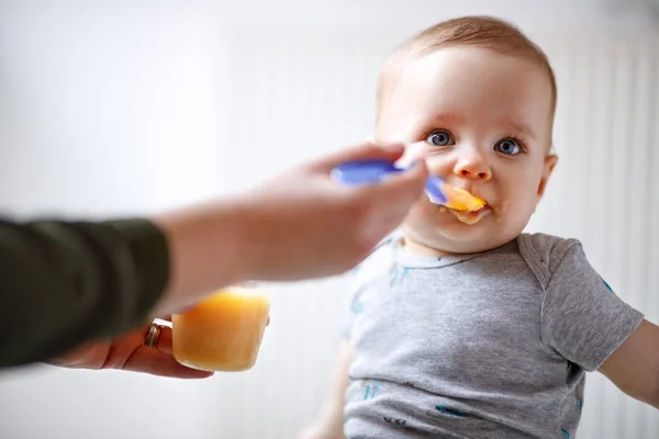 母亲用水果粥喂养可爱的男宝宝 — 图库照片