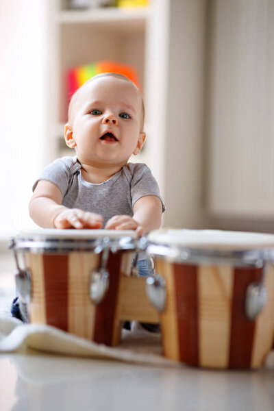 Little cute male child tapping drums
