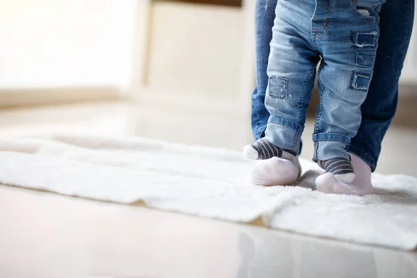 Little boy standing on mom\'s feet and walking together, concept