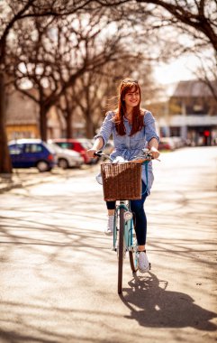 Güzel gülümseyen zencefil kız yolda bir bisiklet ile