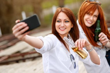 El selfie birlikte yapım şişe iki genç kadınla