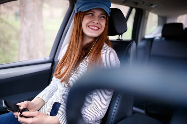 女の子と車でお楽しみいただけます携帯電話から音楽を聴く — ストック写真