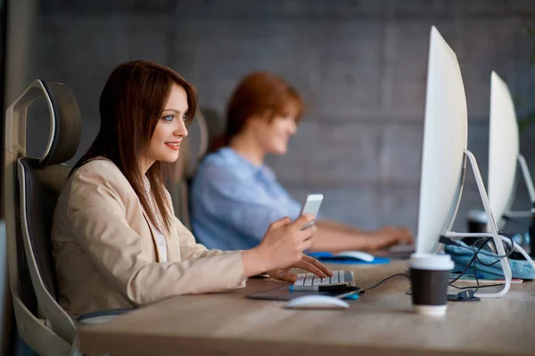 Giovane Donna Designer Utilizzando Smartphone Mentre Lavora Con Computer — Foto Stock