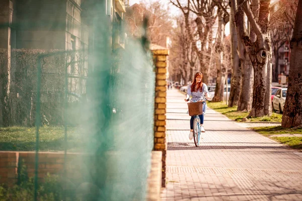 春天在城市骑自行车的年轻妇女 — 图库照片