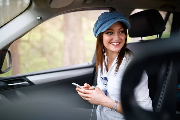 女性在汽车听音乐在手机上 — 图库照片