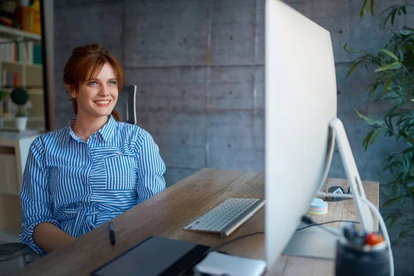 カジュアルな女性デザイナー笑顔と Workplac での作業 — ストック写真