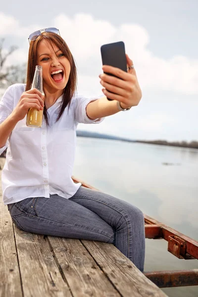 Ładna Dziewczyna Biorąc Selfie Nad Rzeką Trzymając Piwo Relaksujący Dzień — Zdjęcie stockowe