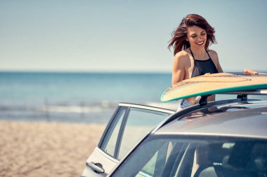 Yaz tatil yol gezisi tatil-genç sörfçü kız onun surfboard ile sahilde