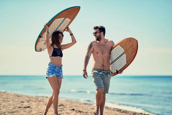 Surfisti Spiaggia Sorridente Giovane Coppia Surfisti Che Passeggiano Sulla Spiaggia — Foto Stock