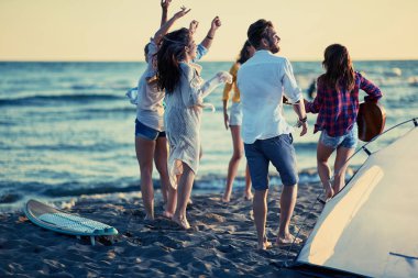 Parti plaj-grubu kumsalda güzel yaz günbatımı üzerinde dans mutlu gençlerin Tarih