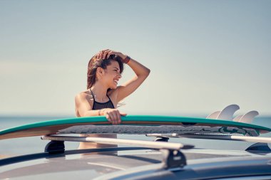 Yaz tatil yol gezisi tatil-genç sörfçü kız araba onun surfboard ile plajda