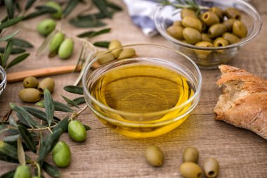 Yunan sızma sağlıklı zeytinyağı ile ahşap arka plan üzerinde taze zeytin