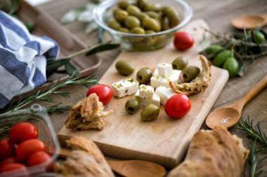 Taze sebze, beyaz peynir ve ahşap masa üzerinde yeşil zeytin Akdeniz salatası