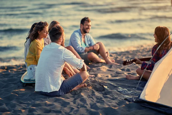 快乐的人概念小组微笑的年轻朋友与吉他在海滩一起乐趣在一起 — 图库照片
