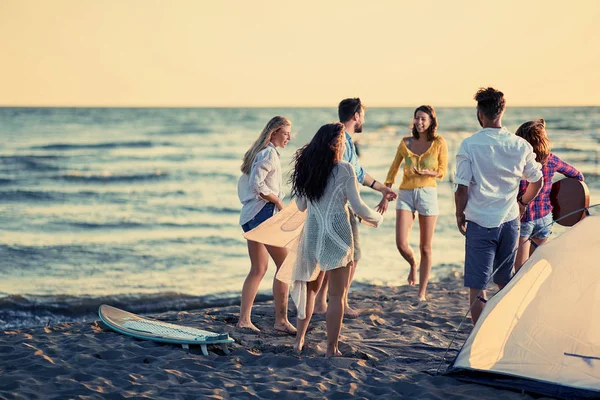 ビーチ 幸せな若い人たちに美しい夏の夕暮れのビーチでダンス パーティー — ストック写真