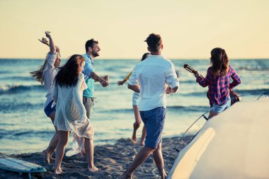 Parti birlikte sahilde güzel yaz günbatımı üzerinde dans beach - mutlu gençlerin Tarih