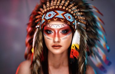 American Indian girl in native costume, headdress made of feathers of wild birds clipart