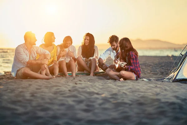 해변에서 기타와 친구의 그룹입니다 기타와 해변에서 모래에 휴식과 일몰에 — 스톡 사진
