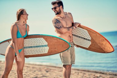 Çekici açık havada - çift sahilde tatil genç sörfçü. Aşırı spor