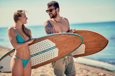 Çekici erkek ve kadın açık havada - sahilde tatil genç sörfçü. Aşırı spor