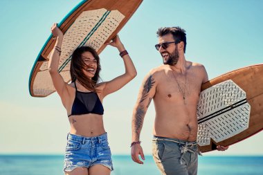 Sahilde yürüyüş ve having fun yaz aylarında sörfçü beach-gülen iki sörfçü