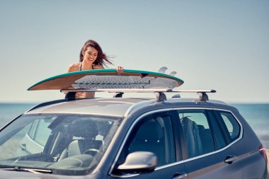Yaz tatil yol gezisi tatil-genç sörfçü kız plajda sörf için hazırlanıyor