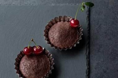 Koyu arka plan üzerinde taze kiraz ile çikolatalı kek