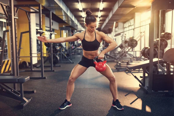 Sporcumuz kol kasları için egzersiz yaparak su ısıtıcısı çan ağırlığı ile 