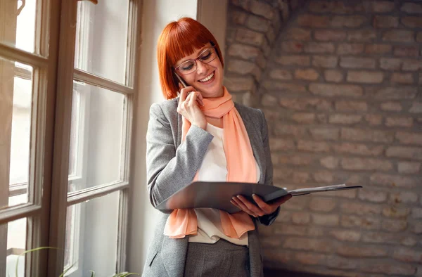 Rothaarige Frau Telefoniert Arbeitsplatz Mit Faszination — Stockfoto