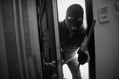 Burglar breaking in a house with crowbar clipart