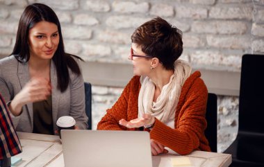 Yeni proje ofiste bilgisayar kullanarak çalışan genç tasarımcı kadınlar