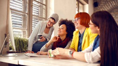 Birlikte bilgisayarda çalışan iş kadınları gülümseyen