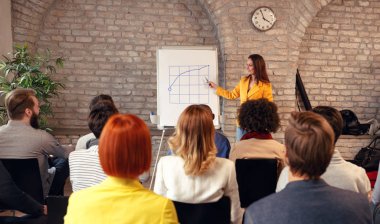 Konulu seminer konferans salonunda grafiği açıklayan iş kadını