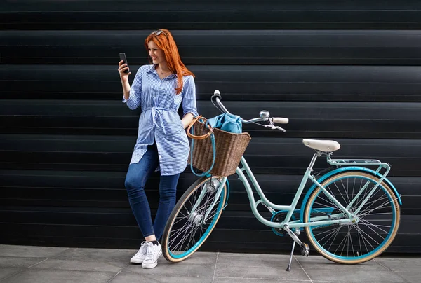 Молодая Женщина Смотрит Сотовый Телефон Рядом Велосипедом — стоковое фото